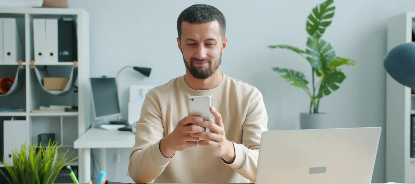Business owner checking messages on his phone in the office