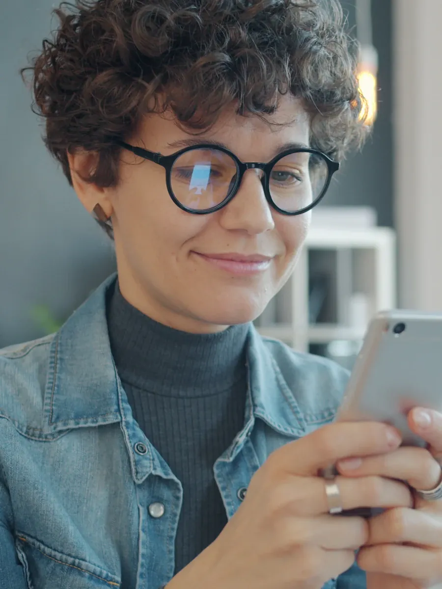 Customer smiling while reading a message on her phone